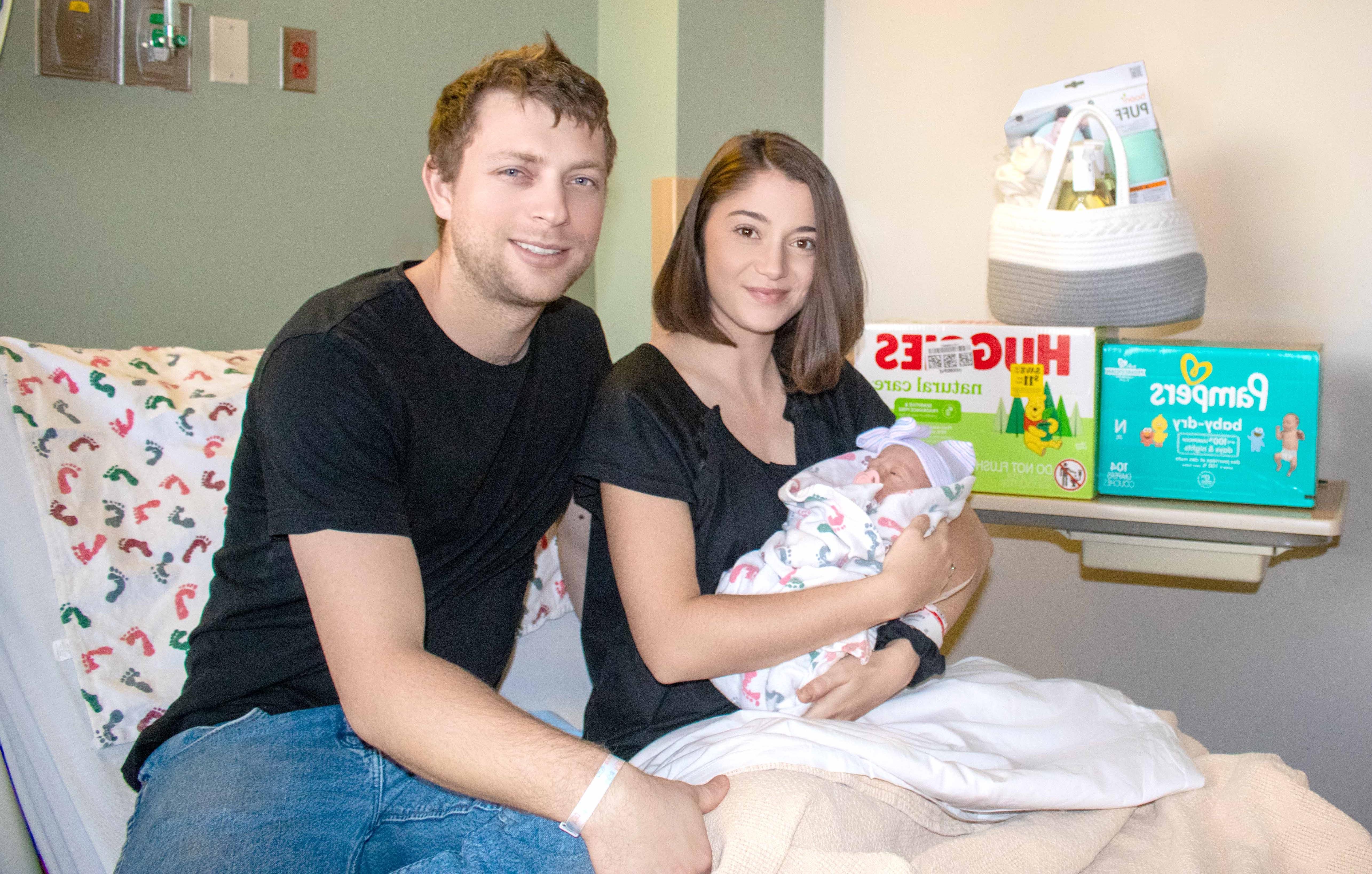 Cierra McCord holds her newborn baby Maeve while her husband, Westin sits next to her in the hospital bed 